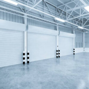 3d rendering of shutter door and concrete floor inside warehouse building for industrial background.